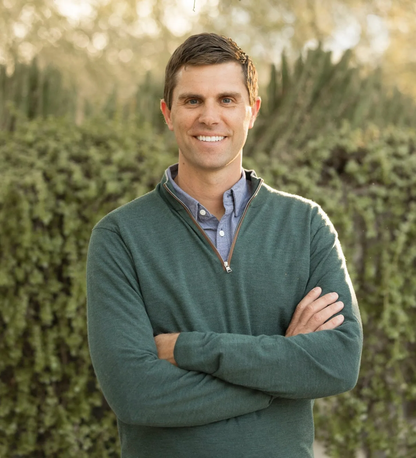 Josh Hustedt, orthopedic surgeon at Nervexa Orthopedics, smiling with arms crossed outdoors